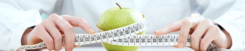 The girl measures the apple with a centimeter ribbon